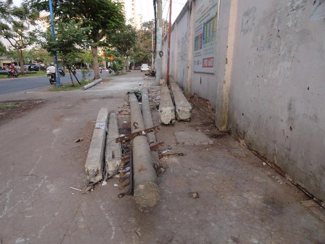 Trụ điện cũ trên vỉa hè, gây nguy hiểm cho người đi đường
