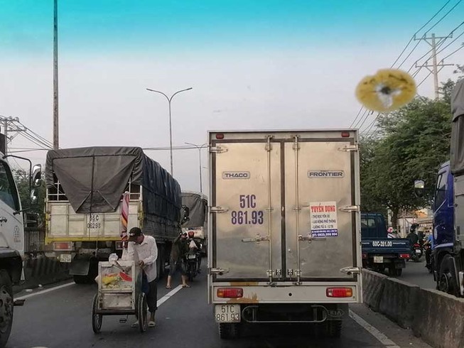 Ngang nhiên bày hàng ra bán giữa làn xe ô tô