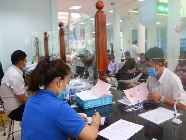 Cán bộ tiếp dân và người dân đến TTHC công TP Thủ Dầu Một đều đeo khẩu trang. Ảnh: LÊ ÁNH
