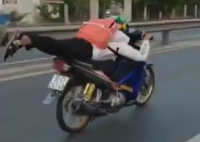 Nam sinh nằm trên xe máy phóng vun vút trên quốc lộ 1