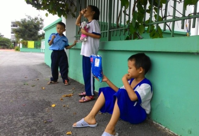 Học sinh vạ vật quanh cổng trường chờ học buổi hai