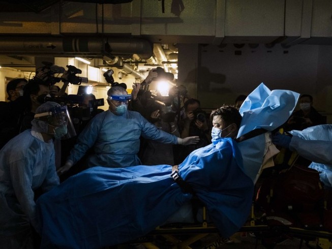 Nhân viên y tế di chuyển một bệnh nhân nhiễm COVID-19 ở Hong Kong, ngày 22-1. Ảnh: AFP