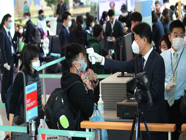 Hành khách được kiểm tra thân nhiệt tại một sân bay Hàn Quốc. Ảnh: YONHAP