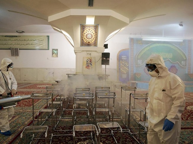 Nhân viên y tế khử trùng Nhà thờ Imam Reza ở TP Mashhad, Iran ngày 1-3. Ảnh: REUTERS