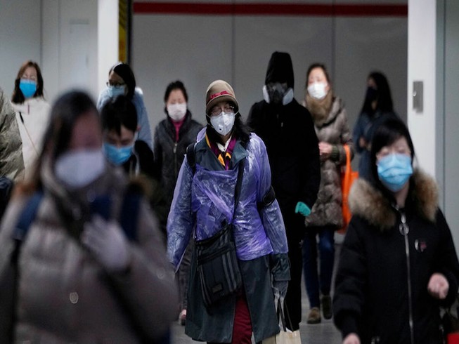 Hành khách đeo khẩu trang chống dịch COVID-19 tại sân bay. Ảnh: REUTERS