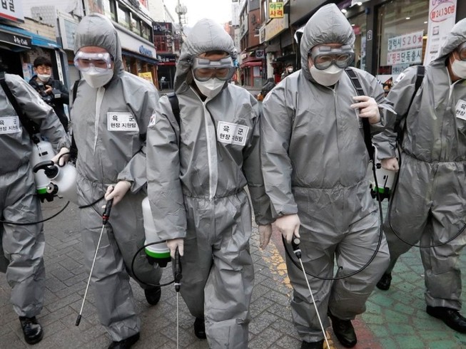 Nhân viên y tế khử trùng đường phố thủ đô Seoul (Hàn Quốc) ngày 4-3. Ảnh: AFP