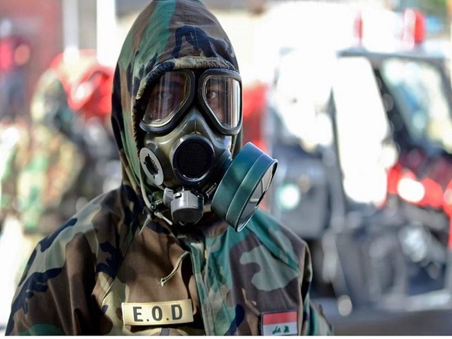 Một nhân viên y tế đeo mặt nạ trước khi khử trùng tại TP Najaf (Iraq).Ảnh: AFP