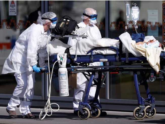 Nhân viên y tế di chuyển một bệnh nhân nhiễm COVID-19 ở TP Strasbourg, Pháp ngày 16-3. Ảnh: REUTERS