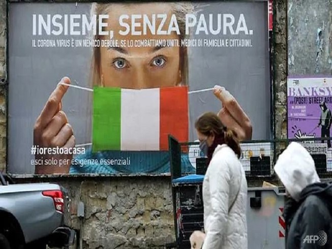 Một tấm poster lớn kêu gọi người dân phải đeo khẩu trang ngừa COVID-19 tại thủ đô Rome, Ý. Ảnh: AFP