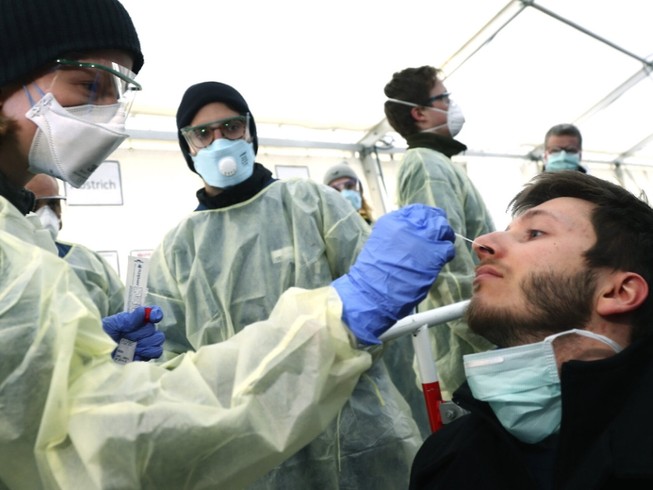 Nhân viên y tế xét nghiệm một người nghi nhiễm COVID-19 ở TP Munich, Đức ngày 29-3. Ảnh: AFP