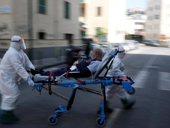 Nhân viên y tế di chuyển một bệnh nhân COVID-19 ở vùng Lombardy, Ý ngày 2-4. Ảnh: AFP