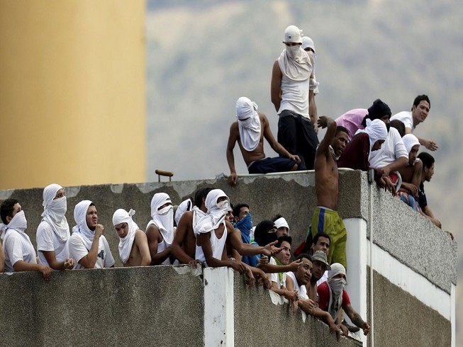 Phạm nhân tụ tập trên nóc nhà tù của cảnh sát ở thủ đô Caracas (Venezuela) trong một vụ bạo loạn năm 2015. Ảnh: REUTERS