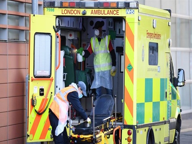 Nhân viên y tế đang khử trùng xe cứu thương tại thủ đô London (Anh). Ảnh: AFP