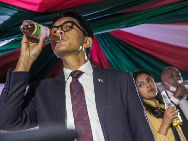 Tổng thống Madagascar, ông Andry Rajoelina, giới thiệu loại nước thảo dược được quảng cáo là "phương thuốc" chữa COVID-19. Ảnh: CGTN