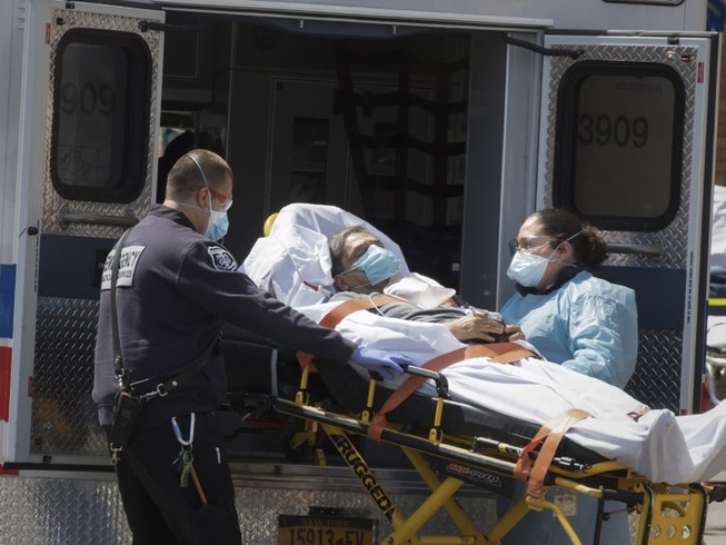Nhân viên y tế di chuyển bệnh nhân COVID-19 ở bang New York, Mỹ ngày 23-4. Ảnh: AFP