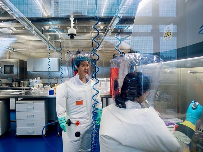 Các chuyên gia Trung Quốc làm việc trong một phòng thí nghiệm thuộc Viện Virus học Vũ Hán hôm 23-3. Ảnh: AFP