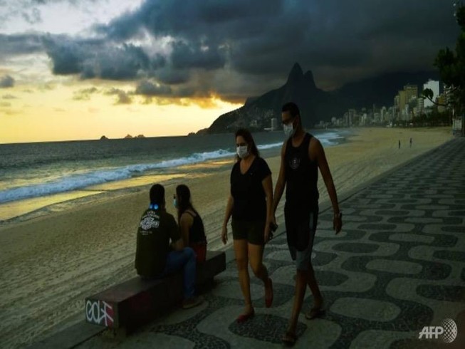 Người dân đeo khẩu trang đi dạo trên bãi biển ở Rio de Janeiro. Ảnh: AFP