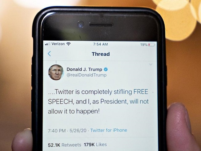 Một người dùng Twitter đang xem đọc đoạn tweet của Tổng thống Mỹ Donald Trump chỉ trích Twitter dán nhãn "thông tin sai sự thật" lên bài đăng của mình. Ảnh: BLOOMBERG