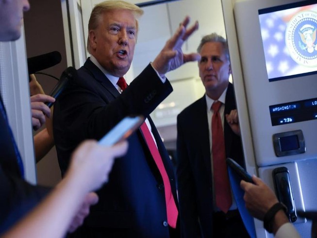 Tổng thống Mỹ Donald Trump (bên trái) nói chuyện với các phóng viên trên chuyên cơ của ông trong khi trở về Washington từ Florida ngày 30-5-2020.