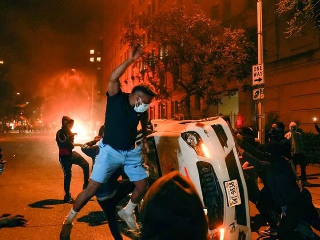 Người biểu tình đập phá xe cảnh sát ở thủ đô Washington, Mỹ tối ngày 1-6. Ảnh: REUTERS
