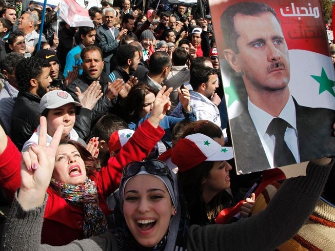 Người dân Syria tuần hành ủng hộ Tổng thống Bashar al-Assad ở thủ đô Damascus tháng 3-2012. Ảnh: REUTERS