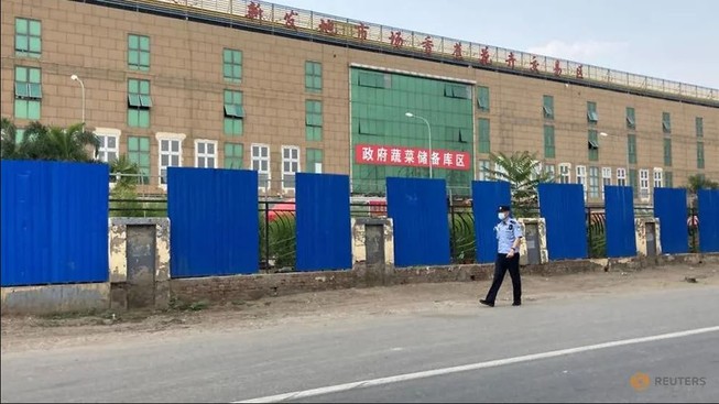 Một nhân viên an ninh kiểm tra khu vực chợ đầu mối Tân Phát Địa ở thủ đô Bắc Kinh (Trung Quốc). Ảnh: REUTERS