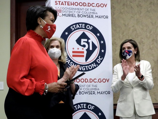 Chủ tịch Hạ viện Nancy Pelosi (áo trắng) và Thị trường Washington D.C. Muriel Bowser (áo đỏ) trong cuộc họp báo ngày 25-6 về dự luật trao quyền bỏ phiếu cho thủ đô của Mỹ. Ảnh: REUTERS