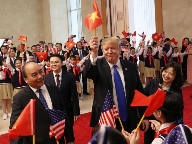 Tổng thống Donald Trump cầm lá cờ Việt Nam vẫy chào cùng Thủ tướng Nguyễn Xuân Phúc khi tham dự thượng đỉnh Mỹ - Triều tại thủ đô Hà Nội hồi tháng 2-2019. Ảnh: REUTERS