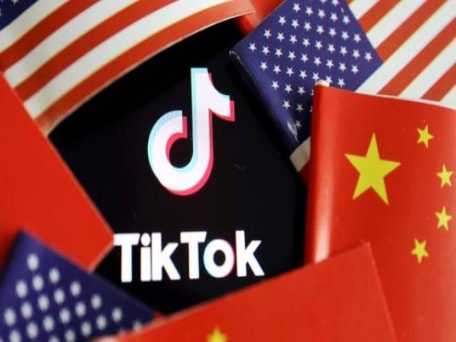 Logo ứng dụng TikTok ở giữa quốc kỳ Mỹ và Trung Quốc.