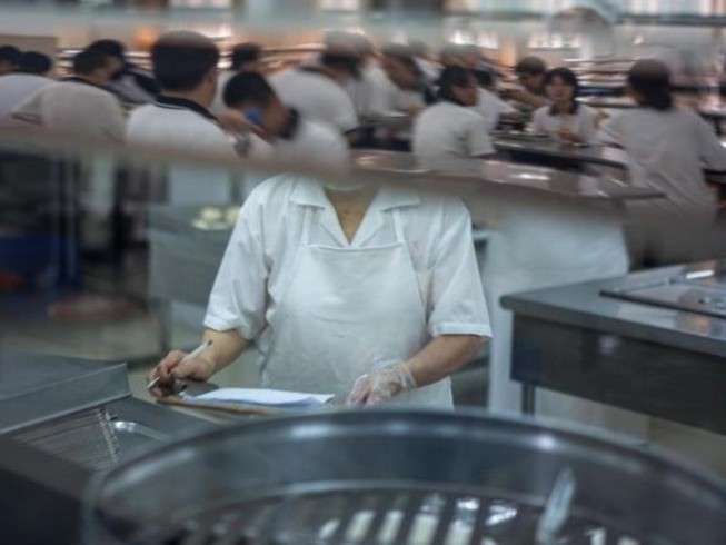 Giáo viên đang chuẩn bị thức ăn cho học sinh. Ảnh: CNN