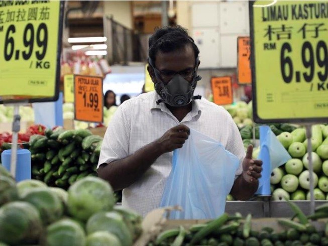 Mang khẩu trang mua đồ siêu thị ở thủ đô Kuala Lumpur (Malaysia) ngày 15-3. Ảnh: REUTERS