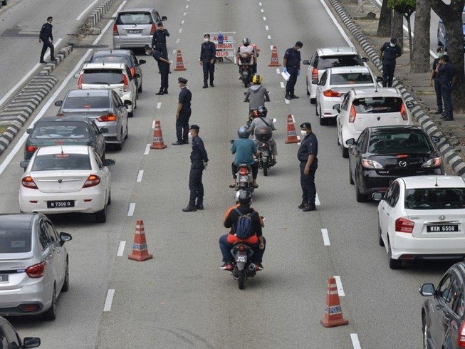 Cảnh sát kiểm soát đi lại người dân trên đường phố thủ đô Kuala Lumpur (Malaysia). Ảnh: AP
