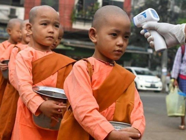 Các chú tiểu được kiểm tra nhiệt độ trên đường phố Yangon (Myanmar). Ảnh: AFP