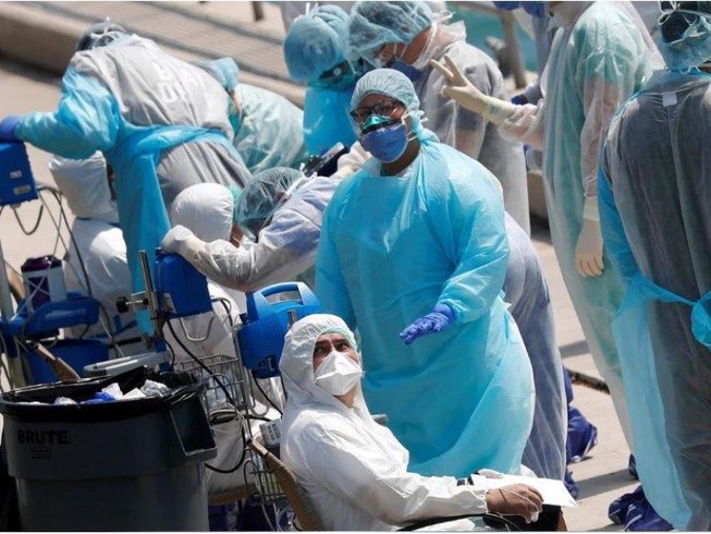 Nhân viên y tế chuẩn bị sơ tán các thủy thủ bị bệnh trên một du thuyền đậu ở cảng Miami, bang Florida (Mỹ) ngày 26-3. Ảnh: REUTERS