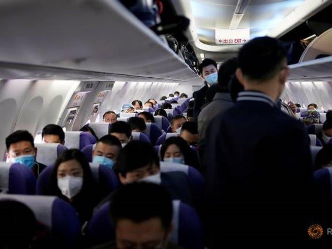 Hành khách đeo khẩu trang trên một máy bay của hãng Shanghai Airlines tại sân bay quốc tế ở Thượng Hải (Trung Quốc) ngày 25-3. Ảnh: REUTERS