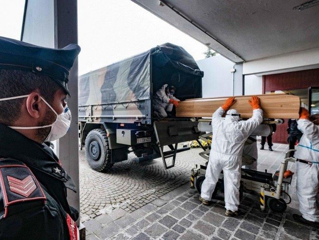 Binh sĩ Ý vận chuyển quan tài người chết vì COVID-19 đến một nghĩa trang gần TP Milan, vùng Lombardy (Bắc Ý) ngày 27-3. Ảnh: EPA