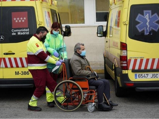 Nhân viên y tế di chuyển một bệnh nhân trên xe lăn tại một bệnh viện ở Madrid (Tây Ban Nha) ngày 30-3. Ảnh: REUTERS