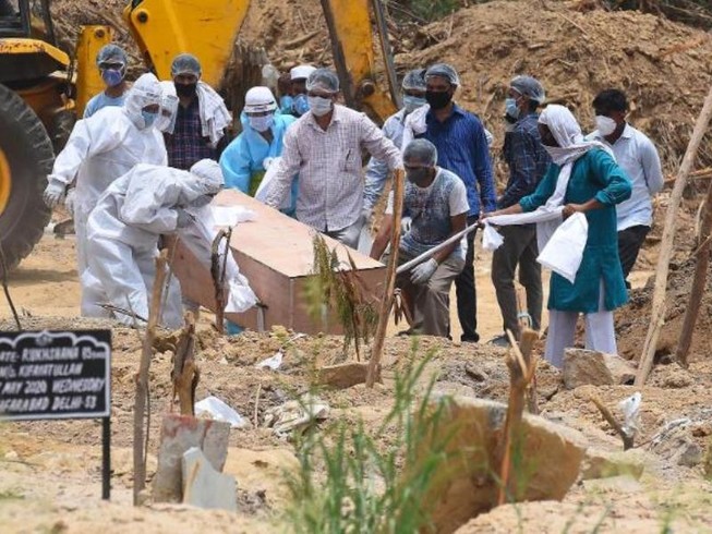 Chôn cất người chết vì COVID-19 ở New Delhi (Ấn Độ). Ảnh: CNN