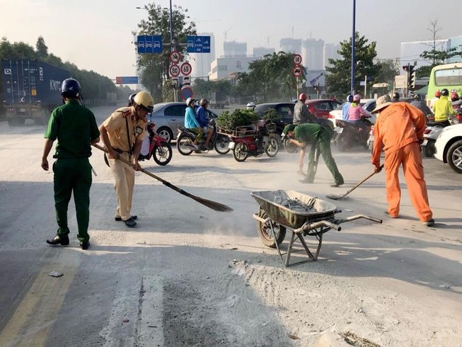 CSGT quét bùn, cát trên đường cho dân khỏi té ngã