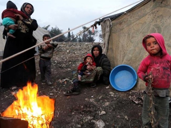 Người tị nạn Syria chạy khỏi Idlib vây quanh một đám lửa ở Afrin, Syria.