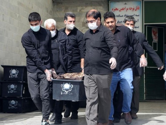 Một cỗ quan tài của bệnh nhân COVID-19 được khiêng đi tại nghĩa trang Beheshte Masoumeh ở TP Qom (Iran).