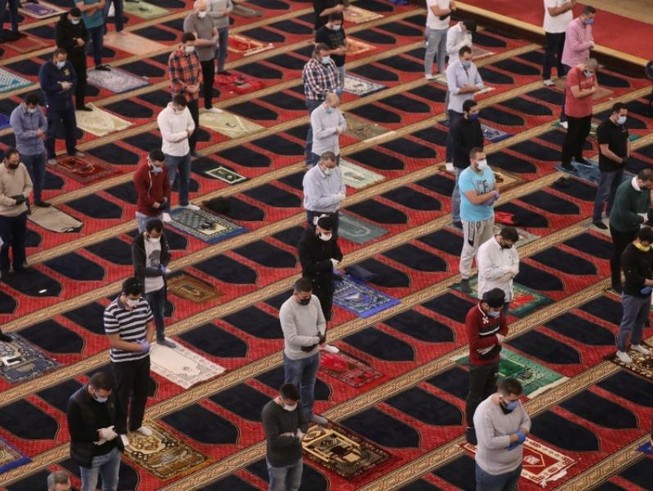 Người dân đeo khẩu trang và thực hiện giãn cách xã hội khi cầu nguyện tại Lebanon. Ảnh: REUTERS