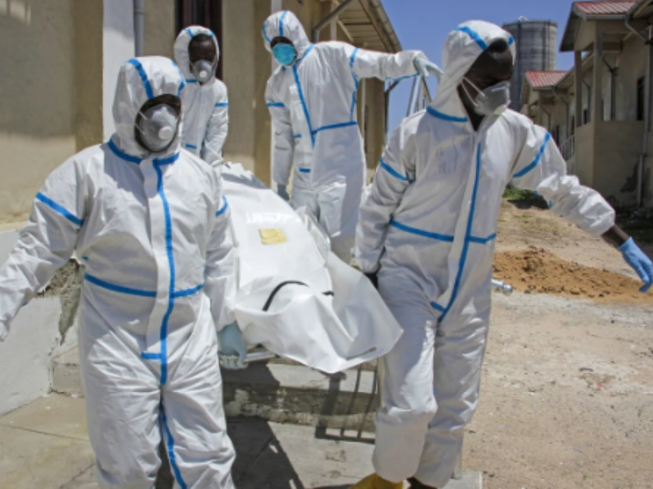 Nhân viên y tế mặc đồ bảo hộ khiêng một thi thể nạn nhân COVID-19 ở Mogadishu, Somalia. Ảnh: AP