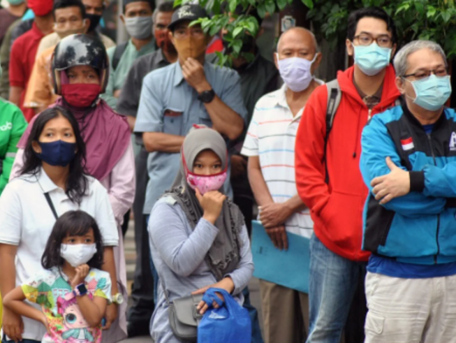 Người dân đeo khẩu trang nghe thông báo từ chính phủ về COVID-19 ở TP Bogor, tỉnh Tây Java, Indonesia. Ảnh: REUTERS