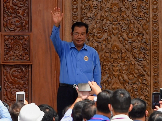 Thủ tướng Campuchia Hun Sen vẫy chào khi đến thăm trụ sở CPP. Ảnh: AFP