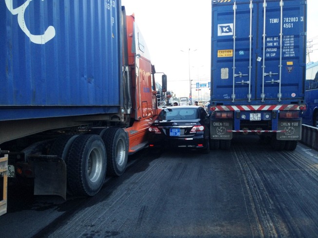 Hai container chèn ô tô, tài xế mắc kẹt