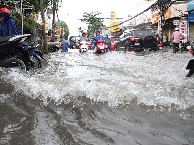 TP.HCM: Mưa như trút nước, người dân bì bõm về nhà