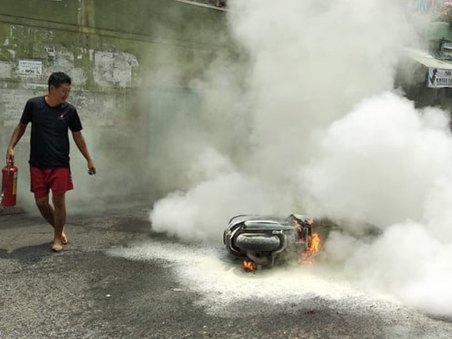 Xe máy đang chạy bốc cháy, người dân hô hoán dập lửa