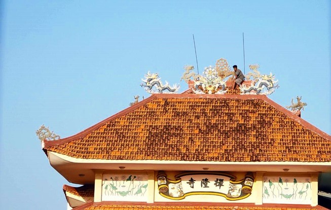 Thanh niên nghi ngáo đá leo lên nóc chùa cố thủ nhiều giờ