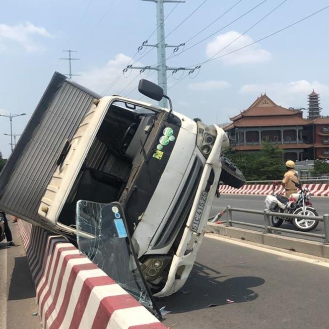 Ô tô tải lao vào làn xe máy, lật trên cầu Bình Lợi